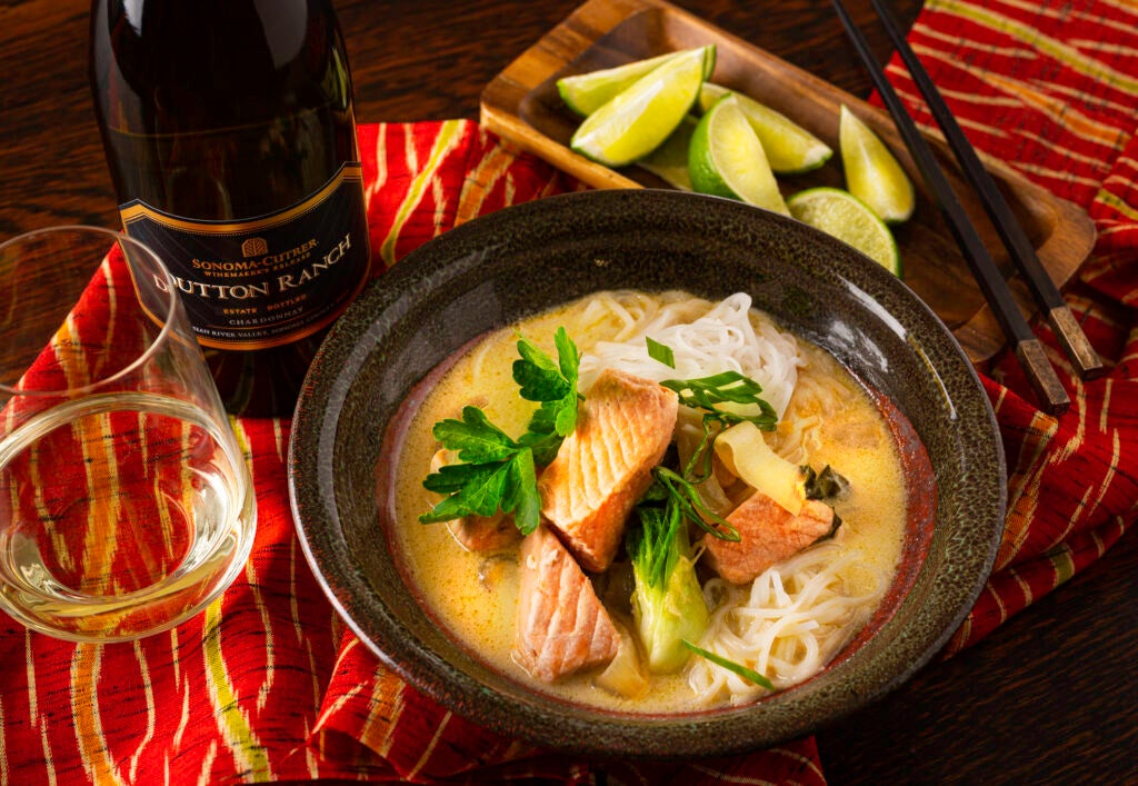 Coconut Miso Salmon Curry in a bowl with a bottle of Sonoma Cutrer Dutton Ranch Chardonnay